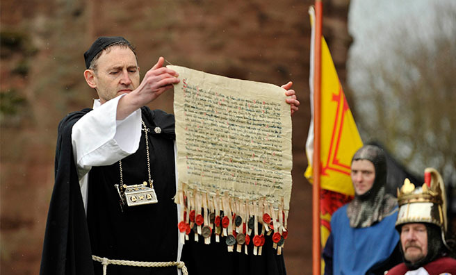 A replica of The Declaration of Arbroath is held aloft during the recreation of the signing of the historic document at the Tartan Day Scotland Festival